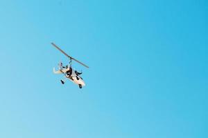 branco pequeno Duplo giroplano autogyro sem uma cabine contra a azul céu. ar passeios para turistas. foto