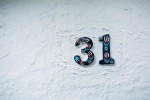 a número 31 é a casa número em a branco cerâmico muro. velho central rua. foto