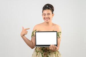 pose de jovem noiva bonita asiática com computador portátil simulado na mão foto