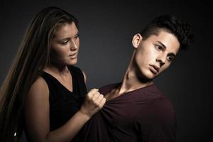 retrato de um lindo casal jovem e feliz contra um fundo cinza escuro foto