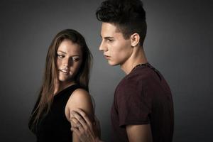 retrato de um lindo casal jovem e feliz contra um fundo cinza escuro foto