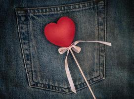 de madeira figura do coração em a fundo do a costas bolso do azul jeans, cheio quadro, Armação foto