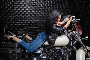 encantador mulher deitado em uma motocicleta foto
