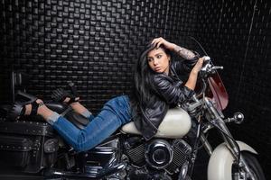 bonita mulher deitado em uma motocicleta foto