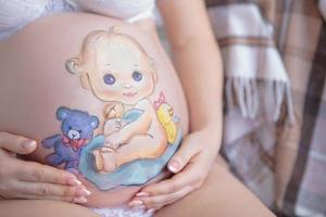 fofa desenhando em a estômago do uma grávida mulher foto