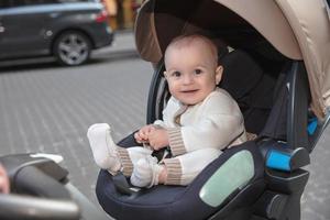 engraçado pequeno bebê sentado dentro uma carrinho de criança foto