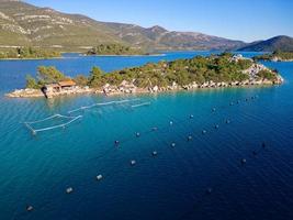 vista aérea do drone da baía de mali ston localizada na península de peljesac. fazendas de ostras na água do mar azul-turquesa. mistura única de água doce e água do mar. foto