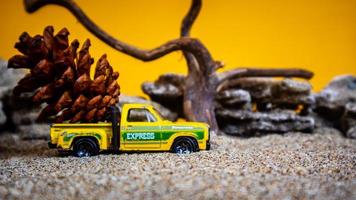 carro de brinquedo transportando pinhas em um fundo laranja foto