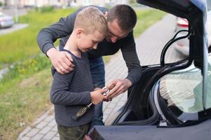 Papai ensina dele fofa filho para usar uma carro reparar ferramenta foto