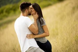 jovem casal apaixonado no campo de grama foto