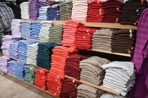 uma conjunto do colori blusas dentro a loja em venda foto