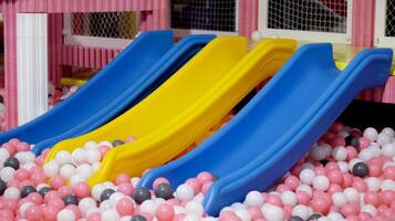 crianças controle deslizante e uma bola piscina às interior Parque infantil permitir crianças fazendo Esportes exercícios ou fisica Educação e Além disso entreter atividade. foto