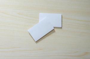uma maquete de papel em branco para cartões de visita em uma mesa de madeira foto