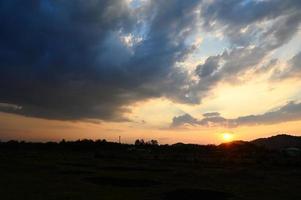 lindo céu luz solar, nascer do sol ou pôr do sol e brilha céu com nuvens colorida e montanha fundo - crepúsculo nuvem em céu dentro campo foto