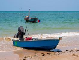 paisagem olhar ver pequenos barco de pesca madeira velhos estacionado costa mar. após a pesca de pescadores em pequena aldeia é pequena pesca local. céu azul, nuvens brancas, tempo claro, praia de phala, rayong foto