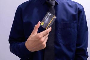 empresário segurando um cartão de crédito foto