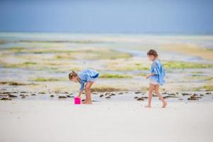 pequeno meninas jogando em a de praia foto