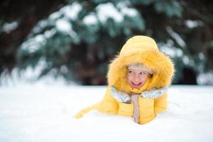 pequeno menina jogando dentro a neve foto