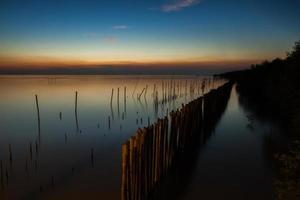 pôr do sol colorido sobre águas paradas foto