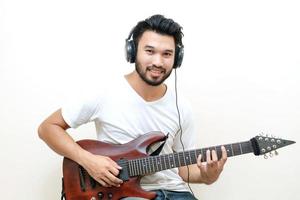 jovem asiático tocando violão foto