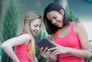 duas garotas se divertindo usando um tablet foto