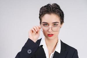 à moda jovem o negócio mulher dentro Preto terno parece com confiança para dentro Câmera. foto