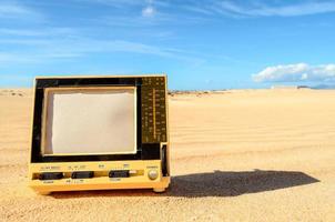 televisão velha na areia foto