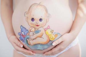 lindo desenhando em a estômago do uma grávida mulher foto