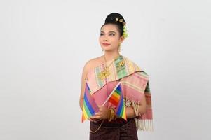 retrato do jovem mulher dentro tailandês nordeste tradicional roupas segurando arco Iris bandeira foto