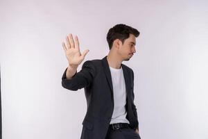 retrato do jovem empresário bonito fazendo parar de cantar com a palma da mão sobre fundo branco foto