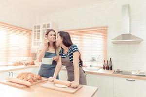 dois caucasiano mulheres cozinhando pizza juntos dentro a cozinha. a conceito do feito em casa Comida e lgbt relacionamentos. família e diversidade conceito. lgbt. foto