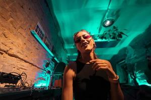 bela dj feminina dançando techno em um pequeno clube foto