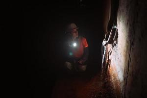 escavadora feminina com lanterna explora o túnel foto