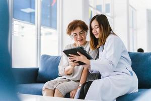 jovem médico consultando paciente sênior na clínica de saúde foto