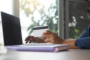 jovem mulheres segurando crédito cartões, gastos dinheiro on-line. ordem conectados foto