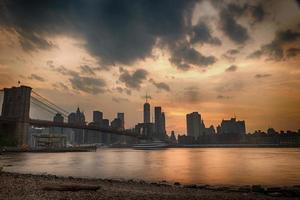 pôr do sol sob a ponte de manhattan foto