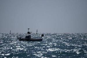 pequeno barco no mar de ondas altas foto