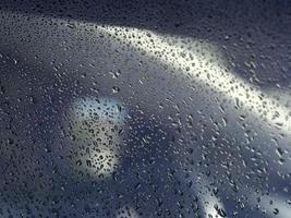 gotas de água de orvalho na superfície metálica azul foto