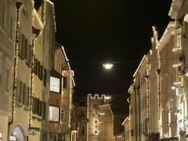 vila de brunico à noite em luzes de natal de dezembro foto