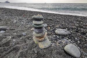 pedra se equilibrando na praia foto
