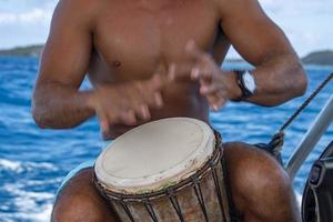 bora bora homem polinésio tocando tambor no barco foto