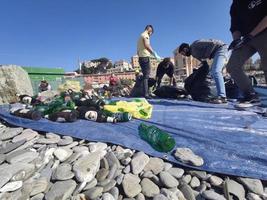 genoa, itália - 28 de fevereiro de 2021 - jovens voluntários coletam plástico e lixo na praia foto