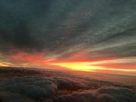 nascer do sol nuvens dentro a céu a partir de avião janela foto