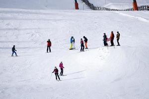 muitos esquiadores esquiando nas montanhas de neve do vale das dolomitas gardena foto