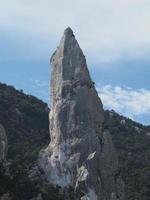 alpinista no penhasco de rocha goloritze à beira-mar sardenha itália foto