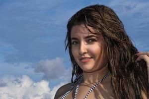 retrato de menina latina mexicana de cabelo preto sorridente no fundo do céu azul foto