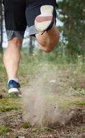 adulto homem dentro Preto calção corre dentro a conífero floresta, conceito do uma saudável estilo de vida foto