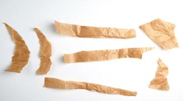 pedaços marrons rasgados de papel pergaminho em um fundo branco foto