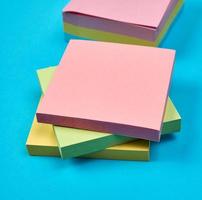 adesivos quadrados de papel vazio multicoloridos sobre fundo azul foto