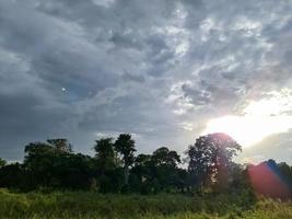 bela vista em raios de sol com alguns reflexos de lente e nuvens em um céu azul foto